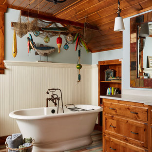 Mid-sized mountain style master blue tile multicolored floor and painted wood floor freestanding bathtub photo in Minneapolis with medium tone wood cabinets, blue walls, granite countertops and furniture-like cabinets