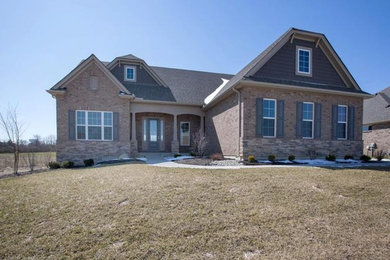 Huge elegant beige two-story brick house exterior photo in Cincinnati with a clipped gable roof and a shingle roof