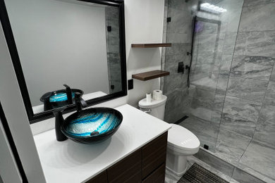 Inspiration for a mid-sized contemporary 3/4 white tile and porcelain tile porcelain tile, gray floor and single-sink doorless shower remodel in Vancouver with black cabinets, a two-piece toilet, white walls, a console sink, quartzite countertops, a hinged shower door, white countertops, a niche and a built-in vanity
