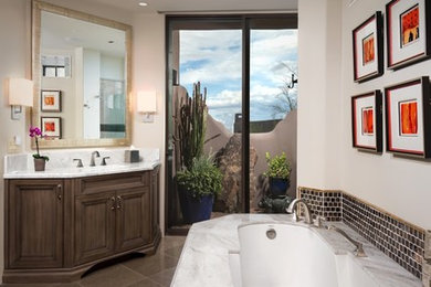 Mid-sized southwest master brown tile and glass tile bathroom photo in Phoenix with recessed-panel cabinets, medium tone wood cabinets, an undermount tub, an undermount sink and marble countertops