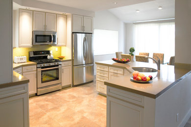 Example of a large transitional l-shaped beige floor eat-in kitchen design in Other with a single-bowl sink, shaker cabinets, white cabinets, stainless steel appliances and a peninsula