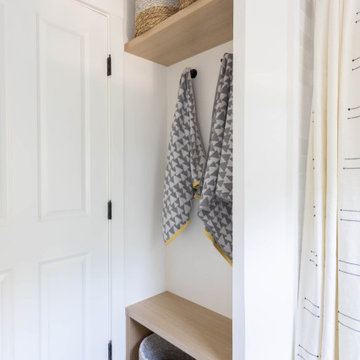 Shower-Tub with Modern Black Plumbing, Wooden Step Stool, and Colorful Accents
