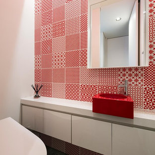 Idee per un bagno di servizio moderno con ante lisce, ante bianche, piastrelle rosse, pareti bianche, lavabo a bacinella, pavimento grigio e top rosso