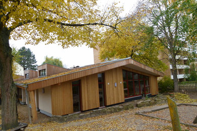 This is an example of a medium sized and brown country bungalow house exterior in Other with wood cladding.
