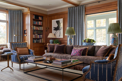 This is an example of a traditional living room in New York with brown walls.