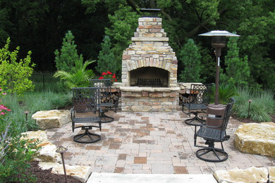 Design ideas for a mid-sized traditional backyard patio in Omaha with a fire feature, brick pavers and no cover.