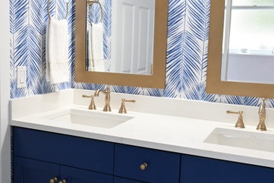 Alcove bathtub - mid-sized coastal kids' white tile and ceramic tile ceramic tile, multicolored floor, double-sink and wallpaper alcove bathtub idea in Miami with recessed-panel cabinets, blue cabinets, a two-piece toilet, multicolored walls, an undermount sink, quartzite countertops, white countertops and a built-in vanity