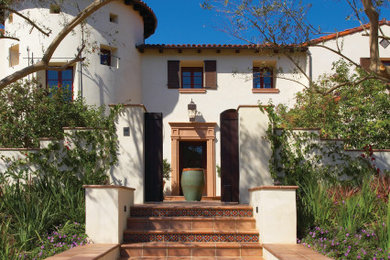 Example of a tuscan white two-story house exterior design in Cedar Rapids with a hip roof, a tile roof and a red roof
