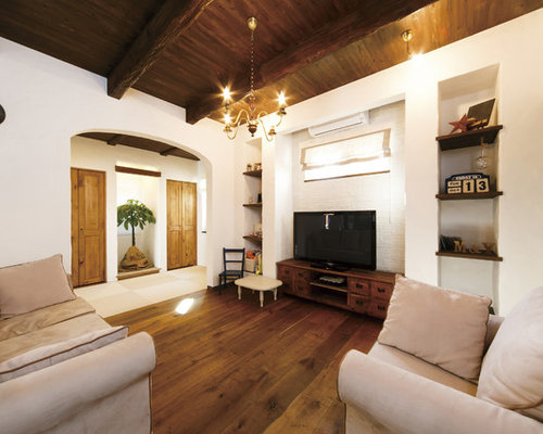 他の地域のラスティックなリビング・居間の写真 (白い壁、無垢フローリング、据え置き型テレビ、茶色い床)