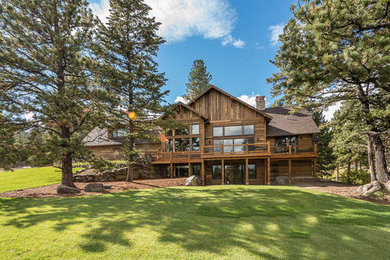 Example of a large mountain style brown two-story wood exterior home design in Other with a shingle roof