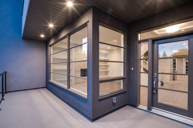 Light wood floor front door photo in Calgary with white walls and a glass front door