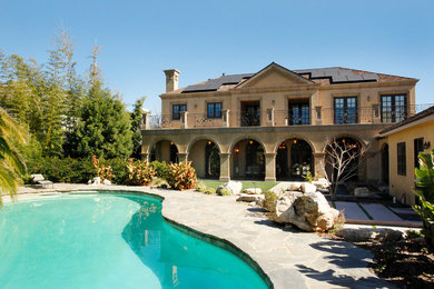 Large transitional beige two-story concrete exterior home idea in Los Angeles