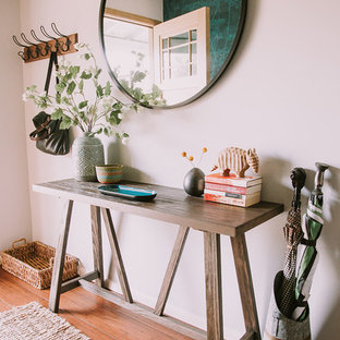 ロサンゼルスの中サイズの片開きドアカントリー風おしゃれな玄関ホール (グレーの壁、竹フローリング、茶色いドア、茶色い床) の写真