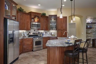Inspiration for a mid-sized mediterranean u-shaped beige floor open concept kitchen remodel in Phoenix with an undermount sink, raised-panel cabinets, medium tone wood cabinets, quartz countertops, beige backsplash, stainless steel appliances, an island and multicolored countertops