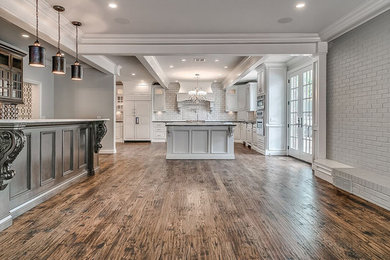 Example of a country open concept medium tone wood floor living room design in Oklahoma City with gray walls, a standard fireplace, a brick fireplace and a media wall