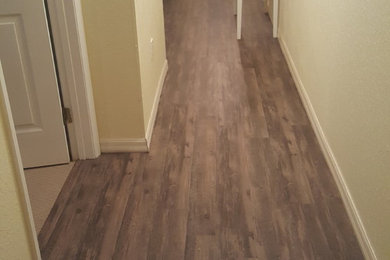 Example of a large vinyl floor hallway design in Tampa with yellow walls