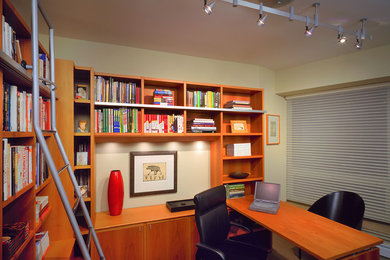 Photo of a small transitional home office in Chicago with a built-in desk, a library, beige walls, beige floor and no fireplace.