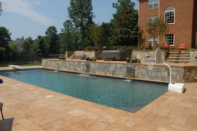 Inspiration for a backyard stone pool fountain remodel in DC Metro