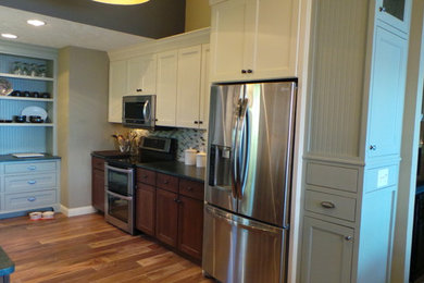 Eat-in kitchen - traditional galley eat-in kitchen idea in Minneapolis with recessed-panel cabinets, white cabinets, soapstone countertops, multicolored backsplash, glass tile backsplash and stainless steel appliances
