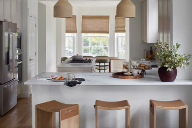 Kitchen - transitional u-shaped medium tone wood floor and brown floor kitchen idea in Denver with an undermount sink, shaker cabinets, beige cabinets, stainless steel appliances and an island