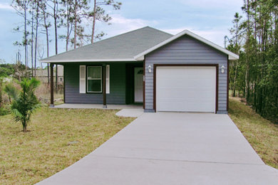 Example of a mid-sized eclectic gray one-story concrete exterior home design in Jacksonville with a shingle roof