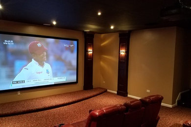 Diseño de cine en casa cerrado clásico grande con paredes beige, moqueta y pantalla de proyección