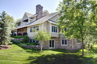 Example of a large mountain style beige three-story concrete fiberboard exterior home design in Milwaukee