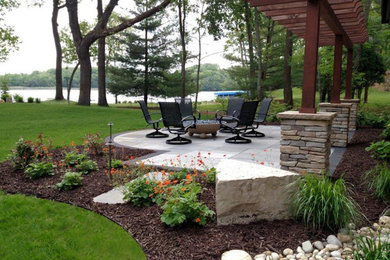 Design ideas for a mid-sized modern partial sun garden in Milwaukee with a fire feature and natural stone pavers.