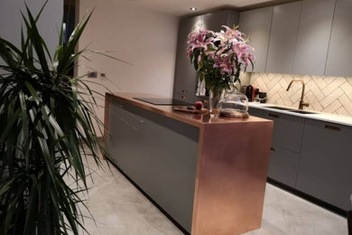 Large rustic kitchen in Surrey with copper worktops and an island.