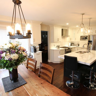 Inredning av ett modernt mellanstort kök, med en undermonterad diskho, luckor med infälld panel, vita skåp, bänkskiva i kvarts, grått stänkskydd, stänkskydd i mosaik, rostfria vitvaror, mörkt trägolv, en köksö och rött golv