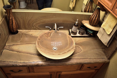 Mid-sized stone slab bathroom photo in Denver with a vessel sink, a one-piece toilet and beige walls