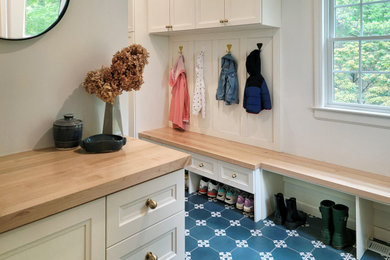 Inspiration for a mid-sized transitional ceramic tile and blue floor mudroom remodel in New York with white walls