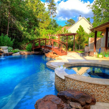 Natural Pool with rock waterfall, bridge, spa, and pergola