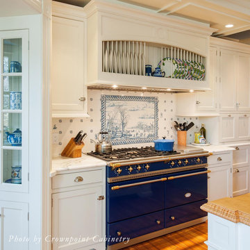 Lacanche range with Delft tile backsplash and plate rack in exhaust hood