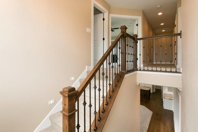 Inspiration for a small transitional carpeted straight wood railing staircase remodel in Cedar Rapids with carpeted risers