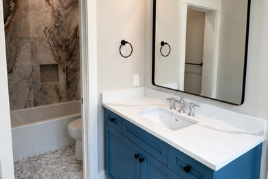 Example of a mid-sized arts and crafts kids' cement tile floor, gray floor and single-sink bathroom design in Charleston with shaker cabinets, blue cabinets, a two-piece toilet, an undermount sink, quartz countertops, white countertops and a built-in vanity