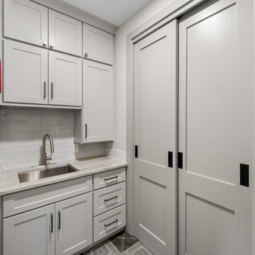 Light Gray Shaker Utility Cabinetry with Marble Countertop and Integrated Slidin