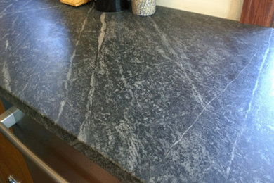 Example of a classic kitchen design in Chicago with a farmhouse sink and soapstone countertops