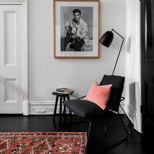 Exempel på en mellanstor klassisk hall, med vita väggar, målat trägolv och svart golv