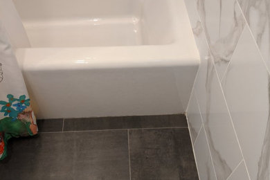 Photo of a transitional master bathroom in New York with white tile, white walls and porcelain floors.