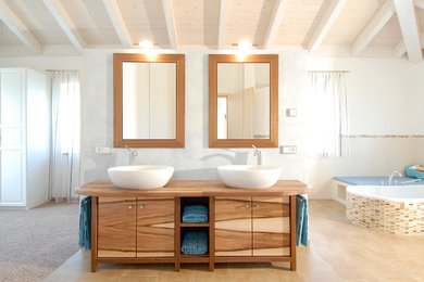 Großes Modernes Badezimmer En Suite mit Aufsatzwaschbecken, flächenbündigen Schrankfronten, hellbraunen Holzschränken, Mosaikfliesen, weißer Wandfarbe, Waschtisch aus Holz, beigen Fliesen und Einbaubadewanne in München