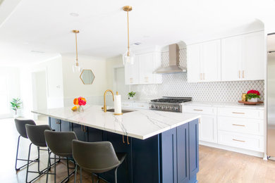 Example of a large classic medium tone wood floor and brown floor kitchen design in Atlanta with an undermount sink, shaker cabinets, white cabinets, quartz countertops, white backsplash, mosaic tile backsplash, stainless steel appliances, an island and white countertops