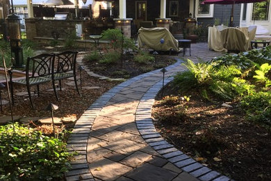 Huge arts and crafts backyard brick patio kitchen photo in Cleveland with a roof extension