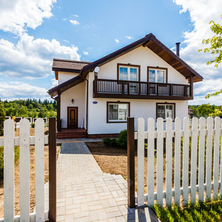 Новые идеи обустройства дома: двухэтажный фасад частного дома белого цвета в стиле кантри с двускатной крышей