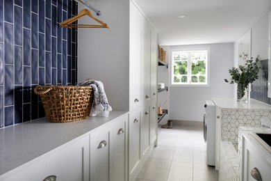 Mid-sized laundry room in Brisbane with white cabinets.