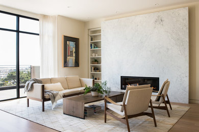 Photo of a mid-sized contemporary formal open concept living room in San Francisco with beige walls, light hardwood floors, a ribbon fireplace, a stone fireplace surround and no tv.