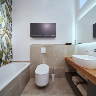 Idées déco pour une salle de bain contemporaine de taille moyenne avec un placard sans porte, des portes de placard grises, une baignoire posée, un WC séparé, un carrelage blanc, un carrelage de pierre, un mur blanc, un sol en brique, une vasque, un plan de toilette en bois, un sol marron et un plan de toilette marron.