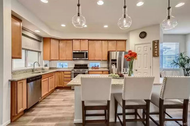 Inspiration for a mid-sized craftsman u-shaped laminate floor, gray floor and wood ceiling kitchen pantry remodel in Denver with a double-bowl sink, light wood cabinets, granite countertops, beige backsplash, ceramic backsplash, stainless steel appliances, an island, gray countertops and recessed-panel cabinets