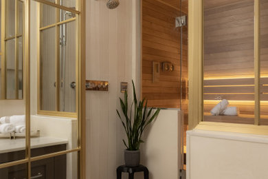 Bathroom - transitional marble floor and single-sink bathroom idea in New York with shaker cabinets, brown cabinets, beige walls, an undermount sink, marble countertops, a hinged shower door and a built-in vanity