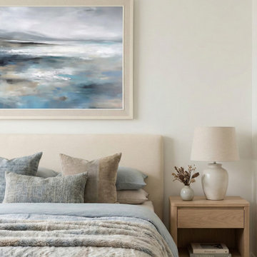 Serene Coastal Bedroom with Abstract Landscape Art and Muted Blue Bedding
